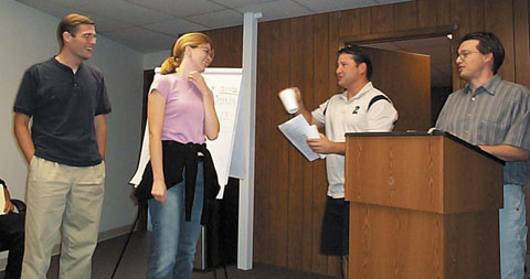 Sean Gutknecht and Mary Swab receive “awards” from Joe Benash and Jeff King during the 2005 Annual Meeting.