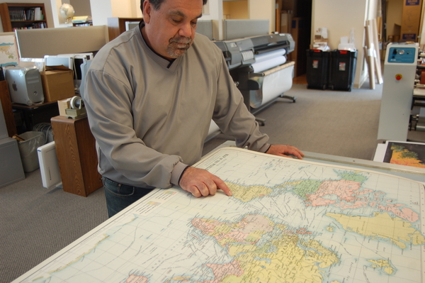 Dave Knipfer, owner and president of Mapping Specialists, looking at a large map on a table